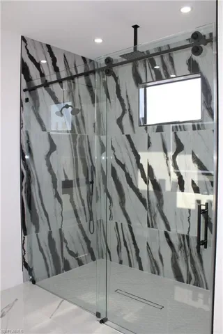 Bathroom featuring a marble finish shower and recessed lighting