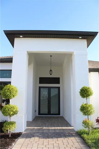 Doorway to property featuring french doors and stucco siding