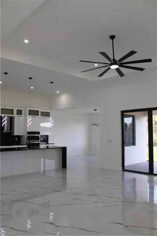 Kitchen with open floor plan, modern cabinets, recessed lighting, dark countertops, and white cabinets