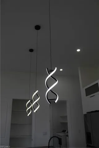 Detailed view of washer / clothes dryer, freestanding refrigerator, and recessed lighting