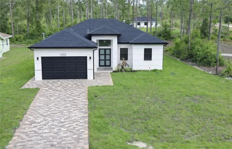 Modern single-story residence with a white exterior and dark shingle roof