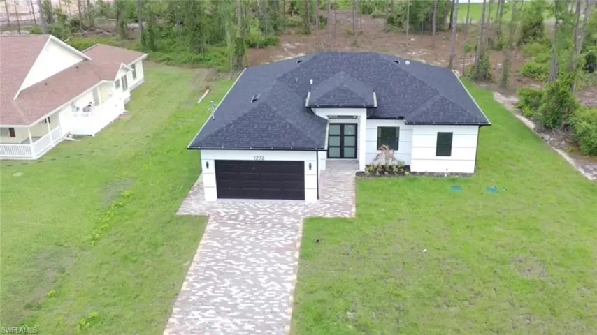Modern exterior with a dark shingle roof, white siding, and a dark garage door