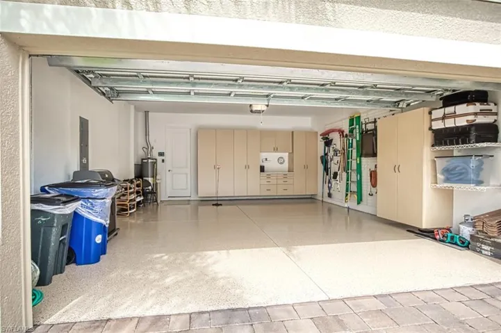 Garage featuring a garage door opener and water heater