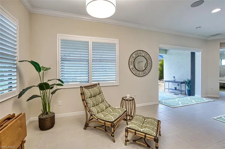 Living area with plenty of natural light, ornamental molding, and light tile patterned floors