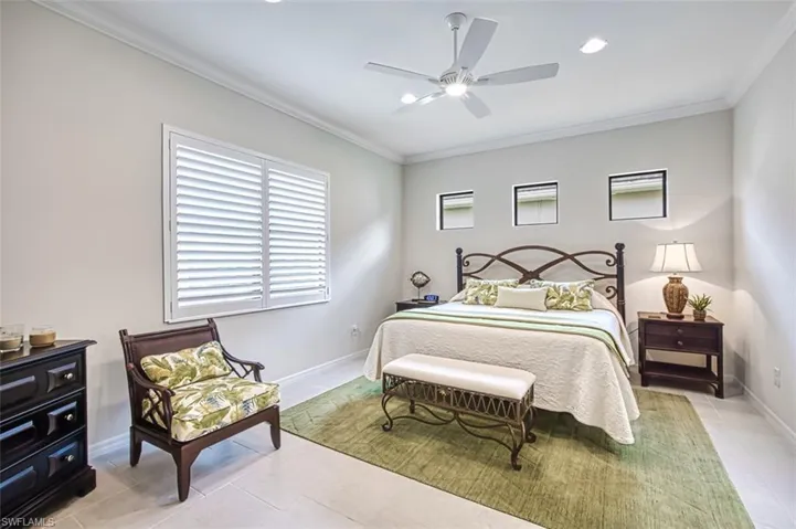 Bedroom featuring ceiling fan, light tile patterned floors, and crown molding