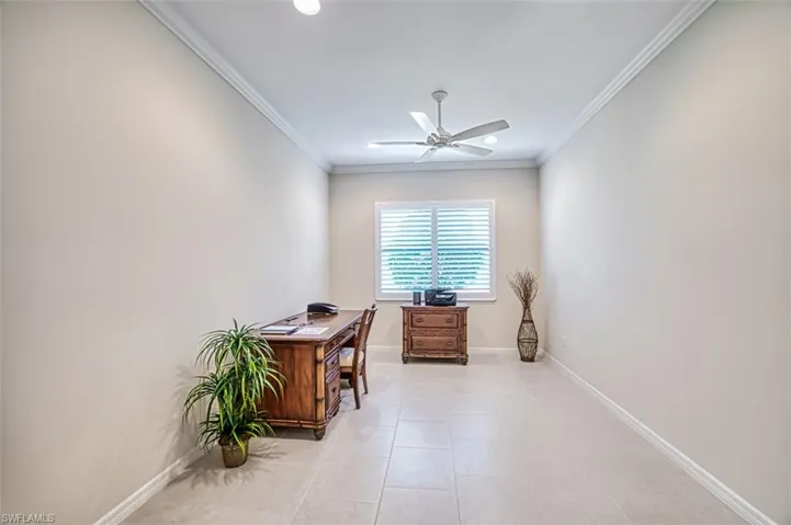 Tiled home office with ceiling fan and crown molding