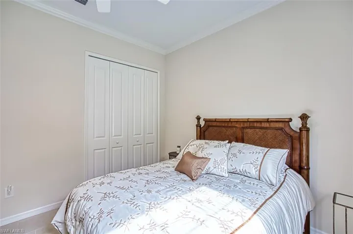 Bedroom featuring ceiling fan, a closet, and crown molding