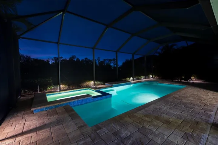 View of swimming pool featuring a lanai, an in ground hot tub, and a patio