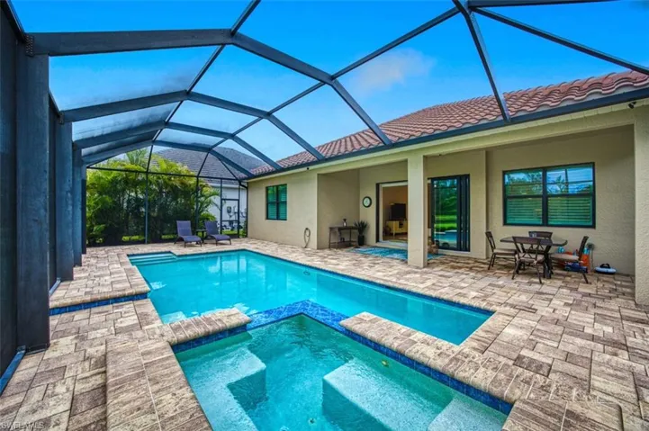 View of swimming pool featuring a lanai, an in ground hot tub, and a patio area