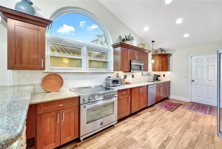 Kitchen with appliances with stainless steel finishes, tasteful backsplash, pendant lighting, and sink
