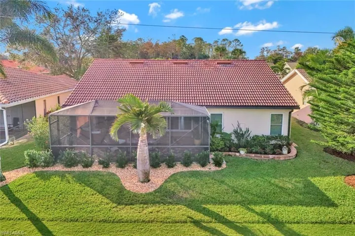 Rear view of house featuring a lanai and a yard