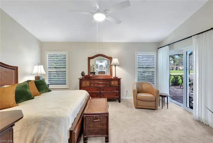 Carpeted bedroom featuring access to exterior, ceiling fan, and lofted ceiling