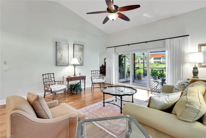 Living room featuring hardwood / wood-style flooring, vaulted ceiling, and ceiling fan