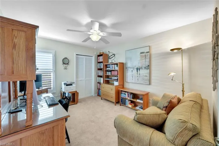 Carpeted office space featuring ceiling fan