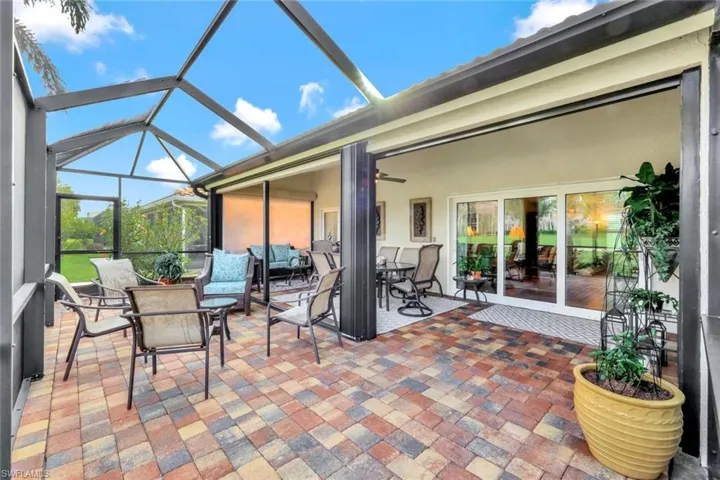 View of patio featuring glass enclosure and ceiling fan