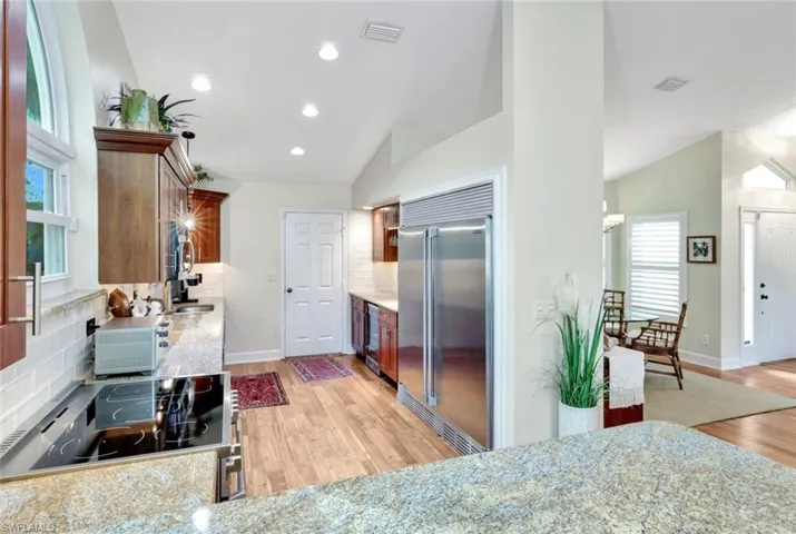 Kitchen with backsplash, lofted ceiling, and stainless steel appliances