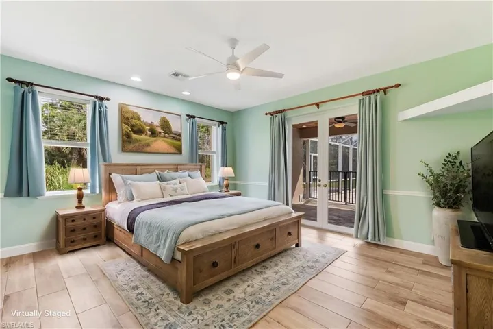 Virtual Staging. Tile Plank flooring with a ceiling fan, dual windows, and exterior access via double French doors leading to the lanai/pool area