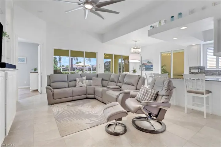 Living area with ceiling fan, a chandelier, recessed lighting, and light tile patterned floors
