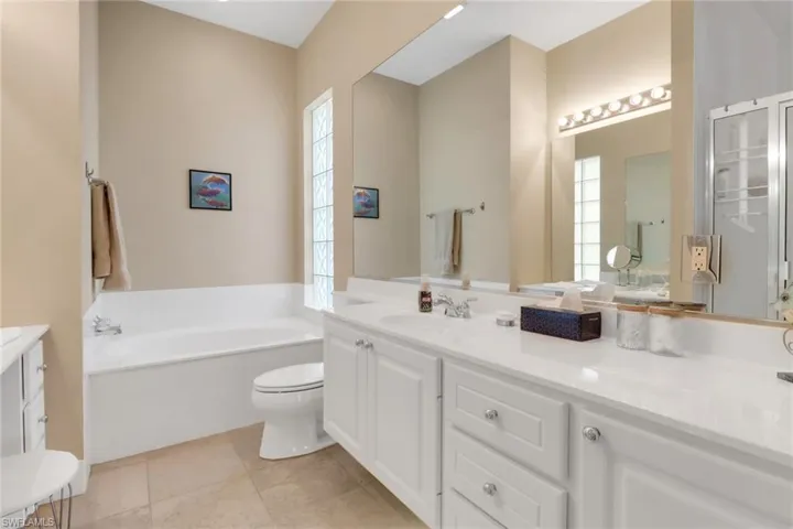 Bathroom with vanity, a garden tub, and tile patterned floors