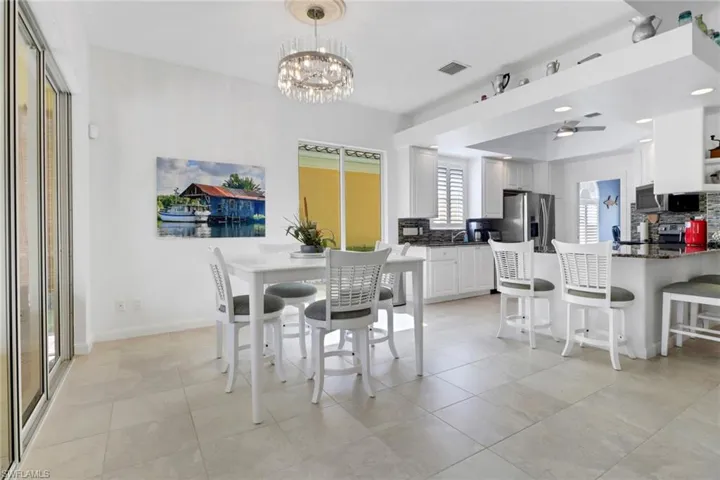 Dining area with light tile patterned floors and a chandelier