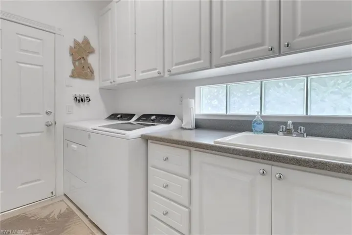 Washroom featuring washing machine and clothes dryer and cabinet space
