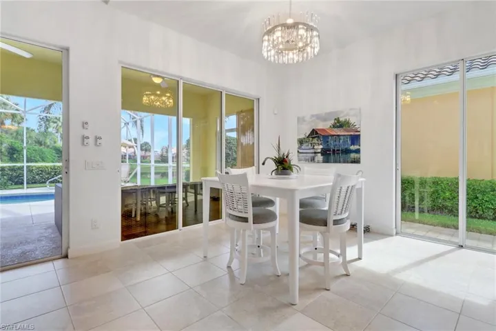 Dining space featuring a chandelier, tile patterned flooring, and a sunroom
