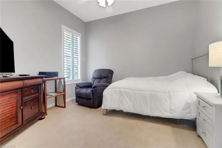 Bedroom with light colored carpet and a ceiling fan