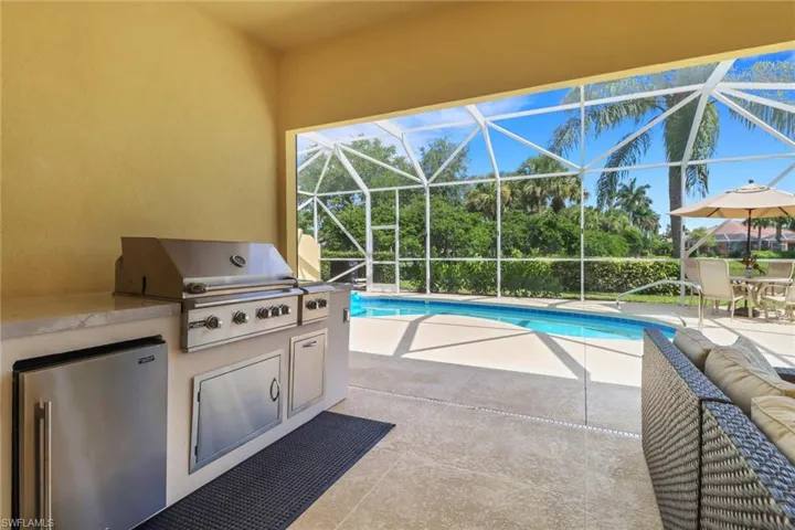 Swimming pool with enclosure, a patio, and area for grilling