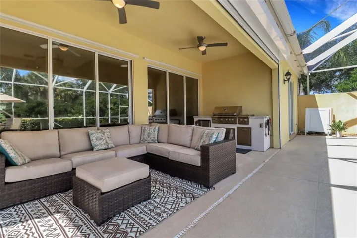 View of patio featuring an outdoor kitchen and a lanai
