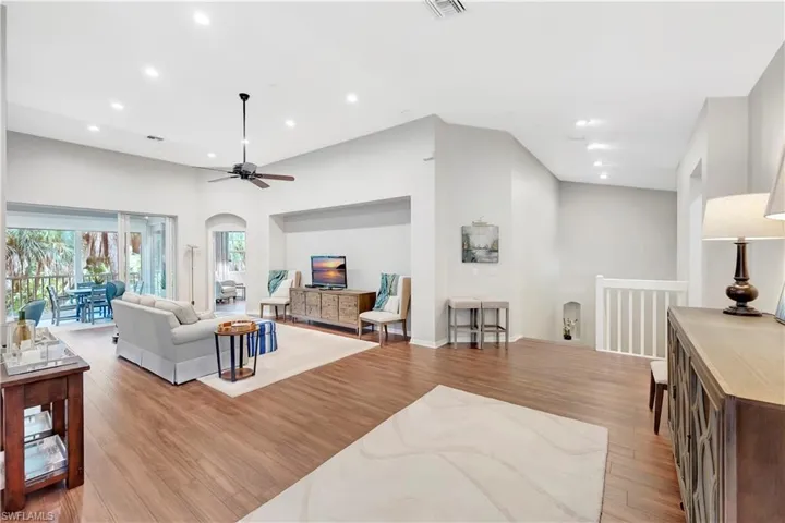 Living room with recessed lighting, arched walkways, and light wood finished floors