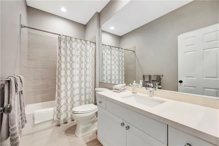 Full bathroom with recessed lighting, toilet, vanity, and shower / tub combo