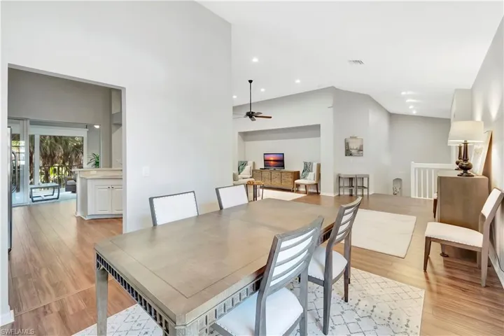 Dining area featuring recessed lighting, light wood-type flooring, ceiling fan, and a towering ceiling