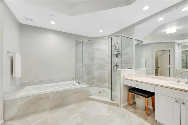 Bathroom featuring vanity, a shower stall, a bath, and visible vents