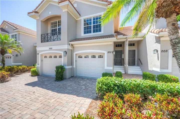 View of front facade with stucco siding, decorative driveway, a garage, and a tile roof