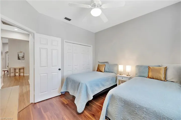 Bedroom featuring a closet, visible vents, a ceiling fan, and wood finished floors