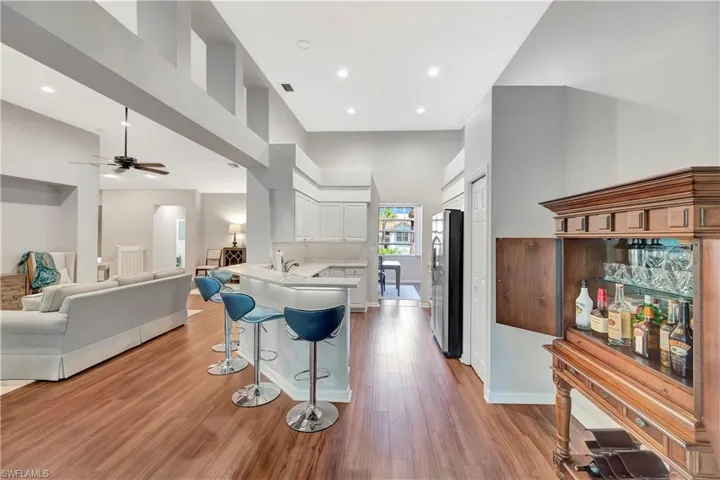 Kitchen with a kitchen bar, a high ceiling, a peninsula, and freestanding refrigerator