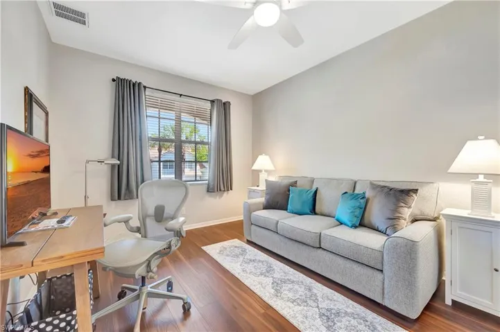 Office space featuring visible vents, baseboards, ceiling fan, and wood finished floors