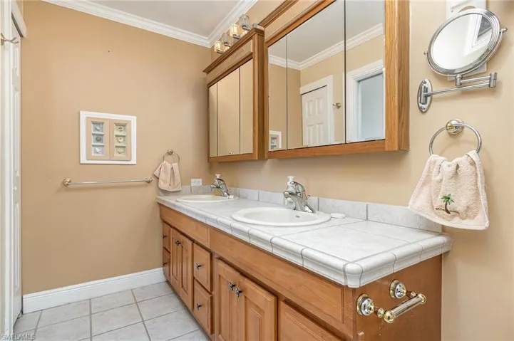 Master Bathroom with tile patterned flooring, vanity, and ornamental molding