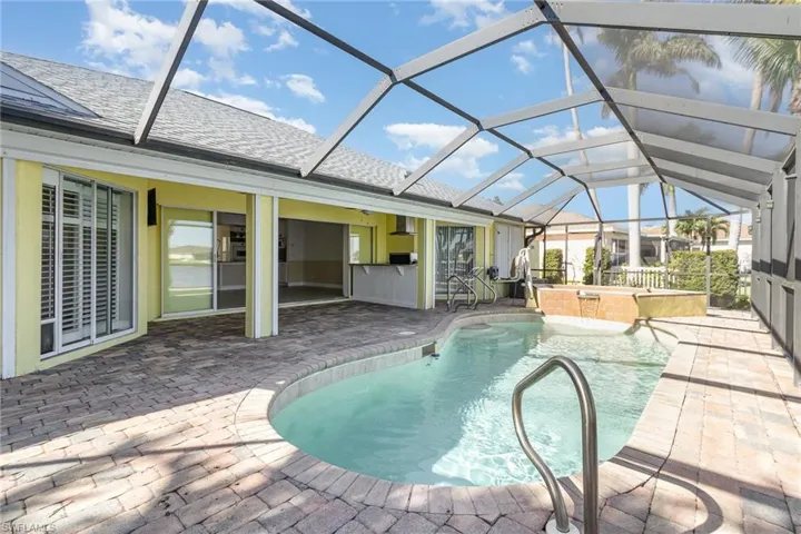 View of pool with a lanai, a patio area, and a jacuzzi