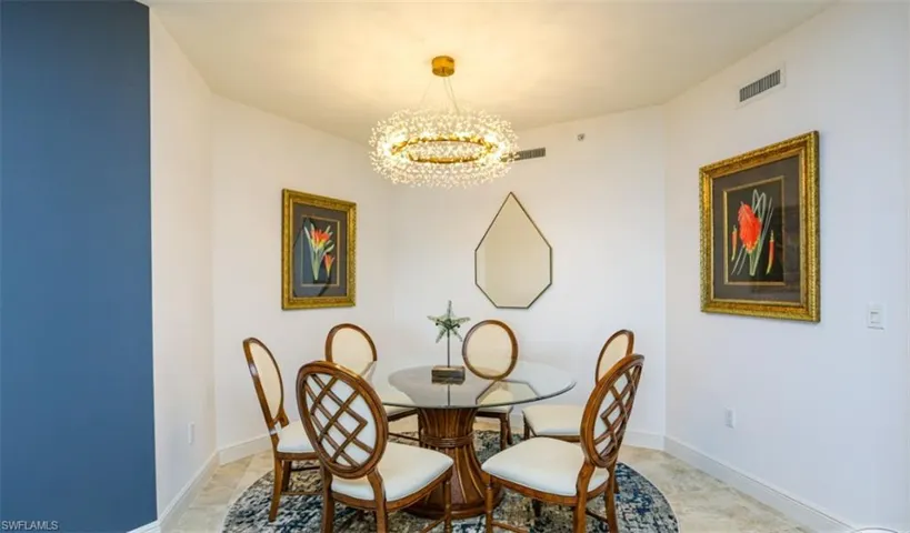 Dining room featuring baseboards, visible vents, and an inviting chandelier