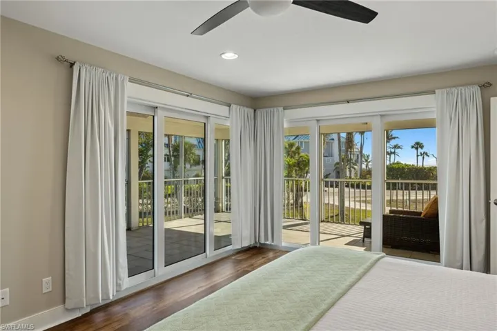 Unfurnished bedroom with access to exterior, multiple windows, recessed lighting, wood finished floors, and a ceiling fan