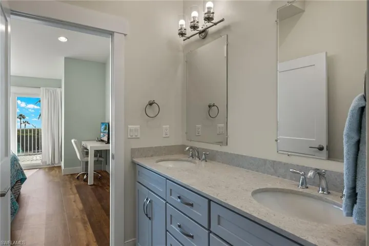Bathroom featuring double vanity, dark wood-style floors, and recessed lighting