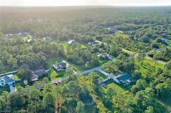 Aerial overview of property's location with a heavily wooded area