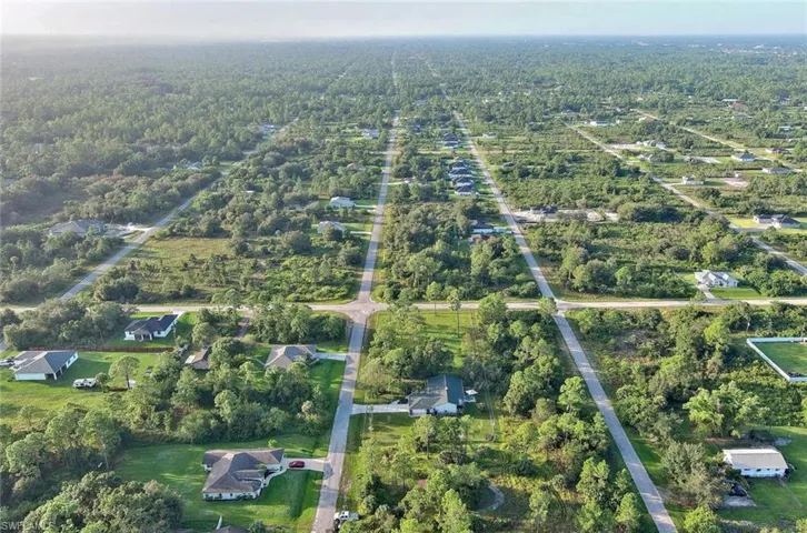 Aerial overview of property's location featuring nearby suburban area and a heavily wooded area
