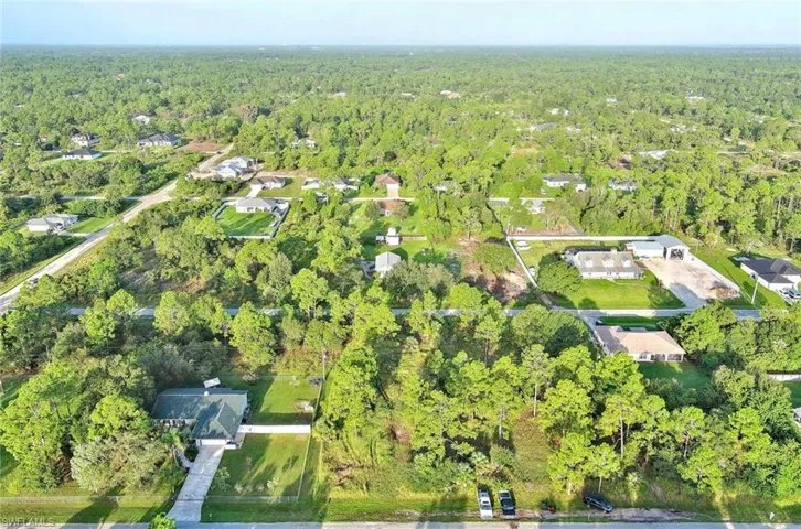 Aerial view of property's location with a heavily wooded area