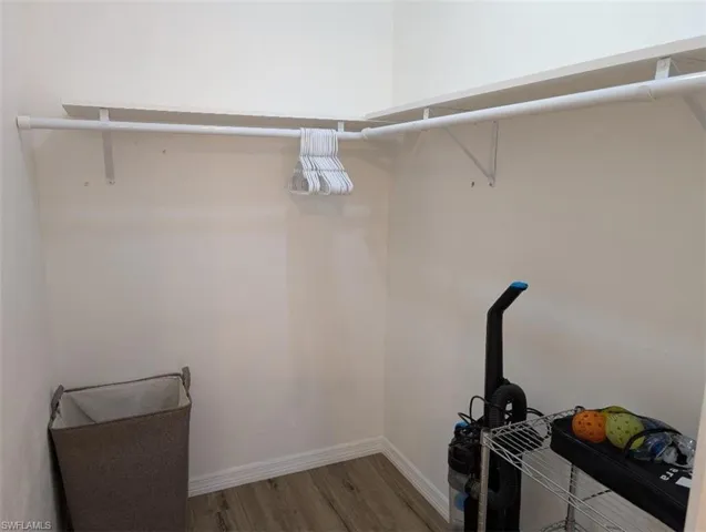 Walk in closet with wood finished floors