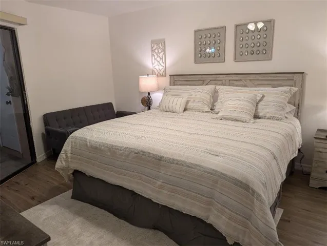 Bedroom featuring wood finished floors and baseboards
