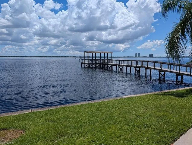 Dock with a water view and a yard
