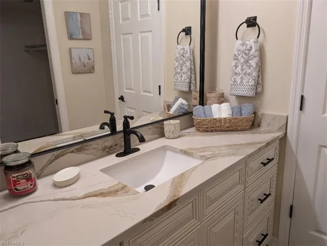 Bathroom featuring vanity and a walk in closet