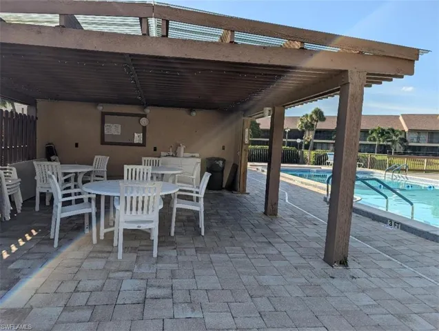 View of patio / terrace featuring a community pool, a pergola, and outdoor dining area